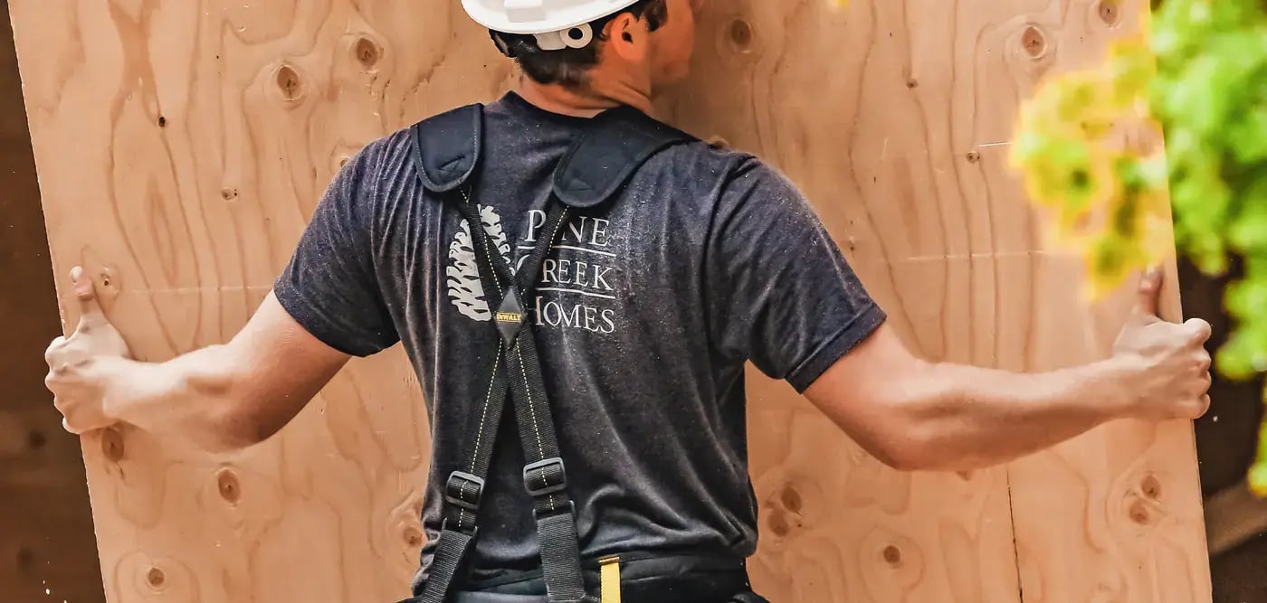 image-of-pine-creek-homes-employee-moving-sheets-of-wood